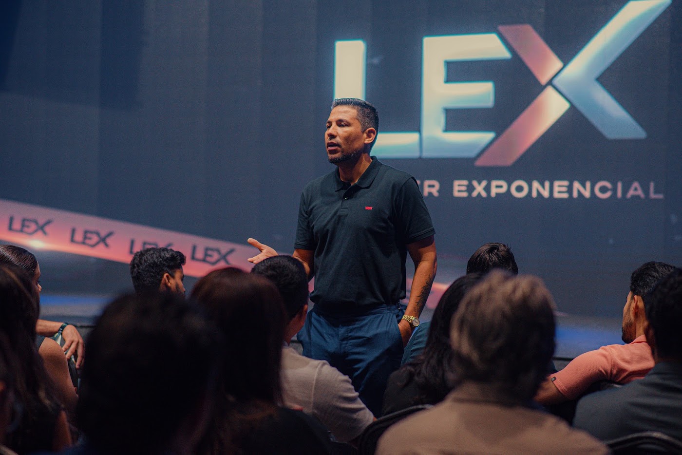 Mateus Ribeiro falando no palco do LEX para uma plateia de empresários